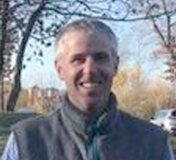 Smiling man facing camera outside 